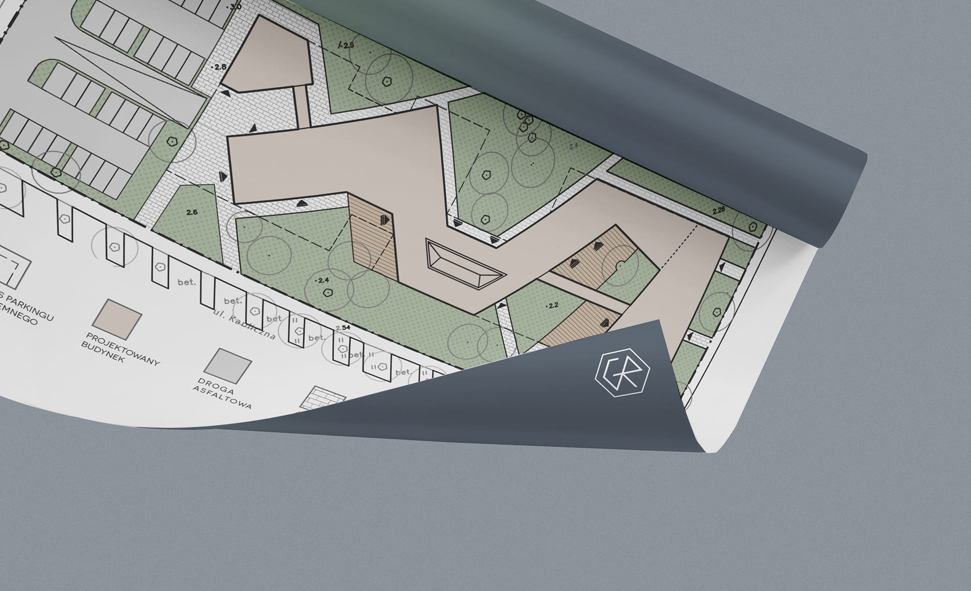Close-up of a coloured landscape site plan with a keyed legend, its corner curling to reveal the CR logo on the back